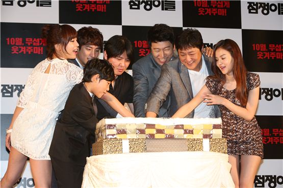 "Fortune Tellers" main cast members Kang Ye-won (left), Lee Je-hoon (second to left), and Kim Soo-ro (third to right) cut a giant Korean rice cake to wish for the film's success at a press conference held at Seoul's AW Convention Center on August 28, 2012. [Younghwain]