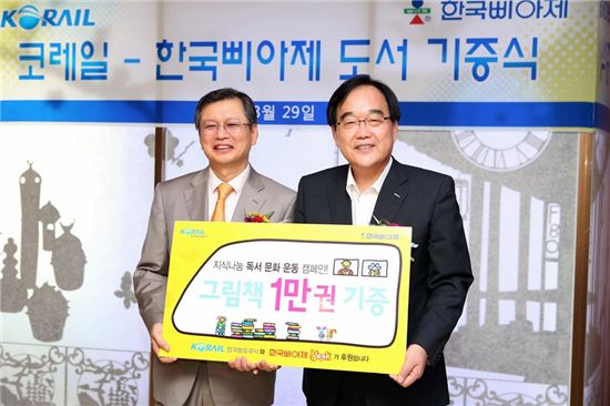 정창영(오른쪽) 코레일 사장이 박종관 한국삐아제 대표이사으로부터 그림책 1만권을 받고 있다.