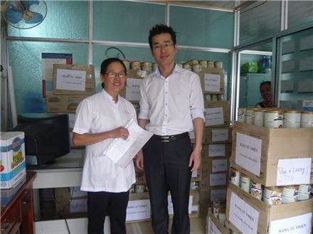 ▲매일유업 김형욱 과장이 베트남 껀터 아동병원의 간호과장 Ms. Ha(미스 하)에 게 분유제품을 전달하고 있다