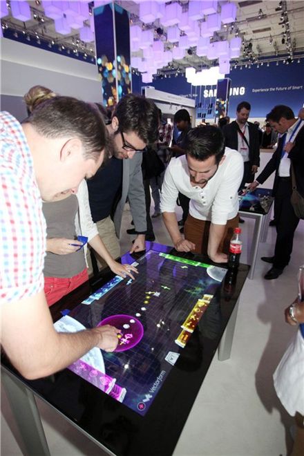 현지시간으로 지난달 31일 독일 베를린에서 열린 IFA2012에서 삼성전자 부스를 찾은 관람객들이 멀티터치 기술이 적용된 '서피스' 디스플레이를 체험해보고 있다.
