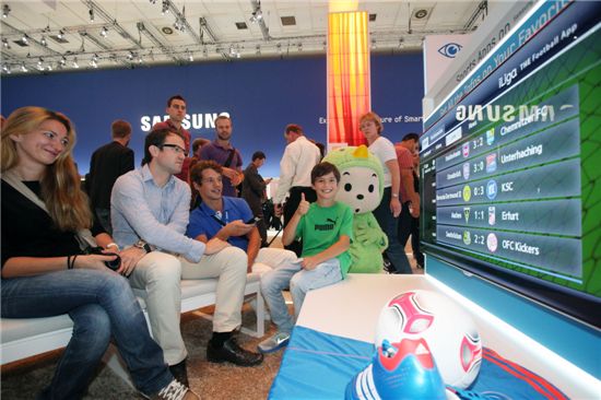현지시간으로 지난달 31일 독일 베를린에서 열린 IFA2012에서 삼성전자 부스를 찾은 관람객들이 삼성 스마트TV의 신규 스포츠 앱인 '더풋볼앱(The Football App)'을 체험해보고 있다. 
