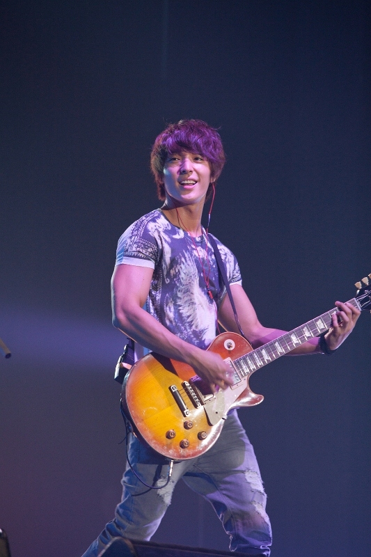 FTIsland's guitars Choi Jong-hoon, donned in an eagle print shirt, smiles while playing the guitar during their concert "TAKE FTISLAND," which took place at Seoul's Olympic Hall on September 1 and 2, in front of several thousand fans. [FNC Entertainment]