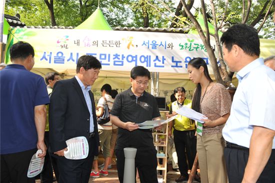 김성환 노원구청장(가운데)가 서울시 주민참여예산제 노원구 부스에서 설명을 하고 있다.