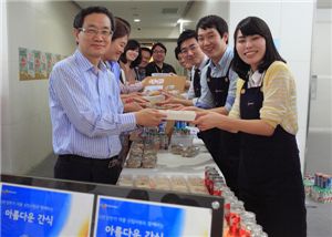 박승환 CJ프레시웨이 대표(왼쪽)와 직원들이 신입사원들로부터 구매한 간식을 건네 받고 있다. 