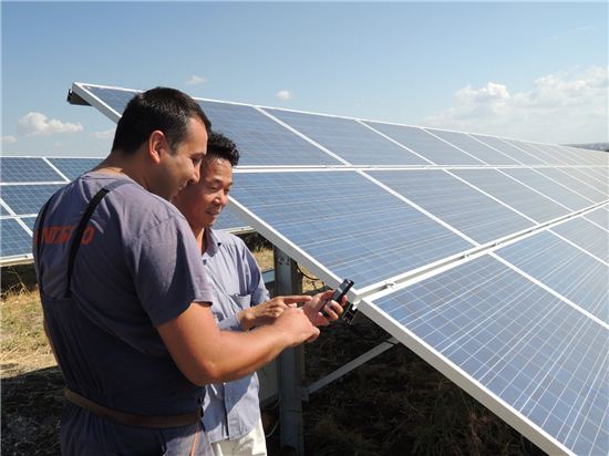 LG CNS 직원과 현지 시스템 운영자가 모바일을 통해 태양광 발전량을 실시간으로 모니터링하고 있다.