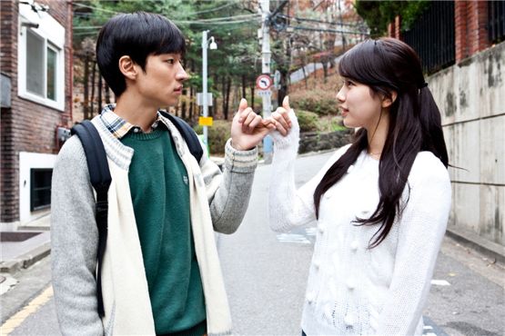 Korean actor Lee Je-hoon (left) and singer-actress Bae Suzy (right) pinkie-swear in a still shot from director Lee Yon-ju's romance film "Arcitecture 101," opened in local theaters on March 22, 2012. [Lotte Entertainment]