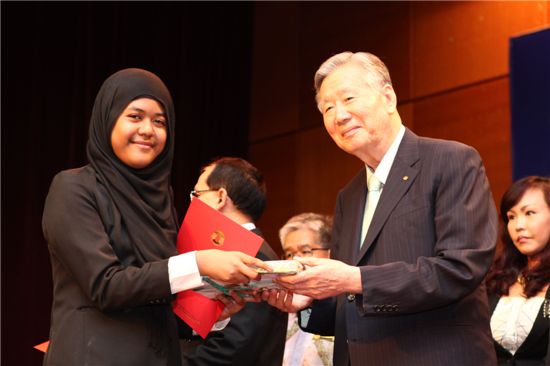 이중근 부영그룸 회장(사진 오른쪽)이 13일 말레이시아 행정수도 푸트라자야에 위치한 교육부 강당에서 개최된 한국형 졸업식 행사에서 졸업생대표에게 기념품을 전달하고 있다. 