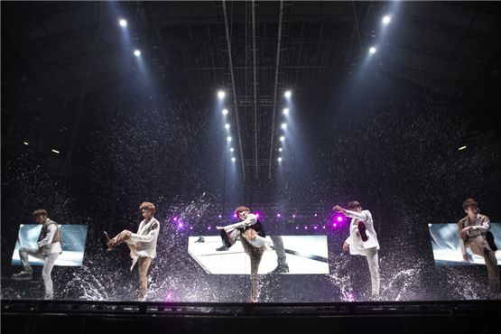 SHINee members Jonghyun (left), Onew (second to left), Taemin (center), Minho (second to right), and Key (right) show syncronized dance moves on the water-covered stage during their second exclusive concert, "SHINee World II," opened at the Taipei Arena in Taiwan between September 15 and 16, 2012. [SM Entertainment]