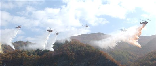 산불현장에서 진화작업을 벌이고 있는 산림항공본부 소속 헬리콥터들의 편대비행 장면
