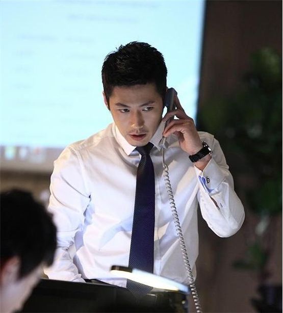 Actor Jang Hyuk, donned in a white shirt and blue tie, is talking on the phone for a scene in SBS' TV series "Midas," which made its premiere on February 22, 2012. [SBS]