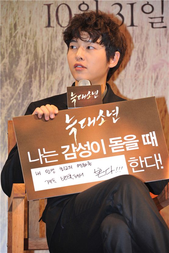 Actor Song Joong-ki shows his answer board that reads "I watch my favorite movies over and over when I am in an emotional mood," during the press conference of his upcoming melo drama pic “Werewolf Boy,” opened at the Apgujeong CGV movie theater in Seoul, Korea on September 26, 2012. [Bidangil Pictures]