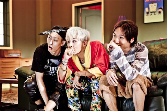 G-Dragon (center) watches TV in the music video for "CRAYON," the title tune off his first solo mini-album "ONE OF A KIND" released on September 18, 2012. [YG Entertainment]