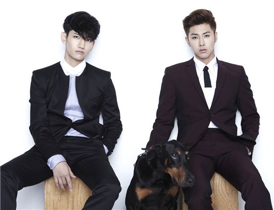 TVXQ!'s Max Changmin (left) and U-Know Yunho (right), donned in black suits, pose with a dog for a group shot taken for their new album "Catch Me" which hit online on September 24, 2012. [SM Entertainment] 