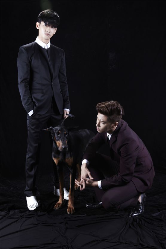 TVXQ! members Max Changmin (left) and U-Know Yunho (right) pose together with a black dog in a photo released for the duo's sixth album "Catch Me," dropped on September 24, 2012. [SM Entertainment]