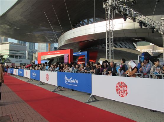 People gather around the red carpet to get a closer look of renowned stars in front of the Busan Cinema Center located in Busan, South Korea, on October 4, 2012. [Kim Min-young/10Asia]
