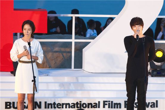 Korean actress Song Ji-hyo (left) and singer-actor Kim Jae-joong (right) of boy band JYJ say hello to fans at the 17th Busan International Film Festival's Outdoor Stage in Haeundae BIFF village in Busan, South Korea, on October 5, 2012. [Lee Jin-hyuk/ 10Asia]