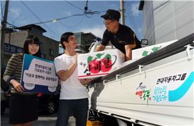 기프트카 주인공 김관중(남, 49) 씨(트럭 안)가 복지관 식구들에게 과일을 무료로 나눠주고 있다.