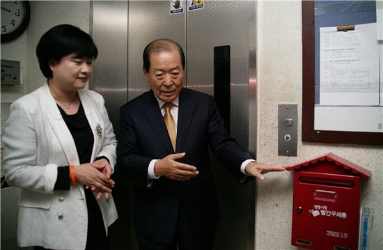박홍섭 마포구청장(오른쪽)이 성산아파트 내 마련된 빨간우체통을 가르키고 있다.