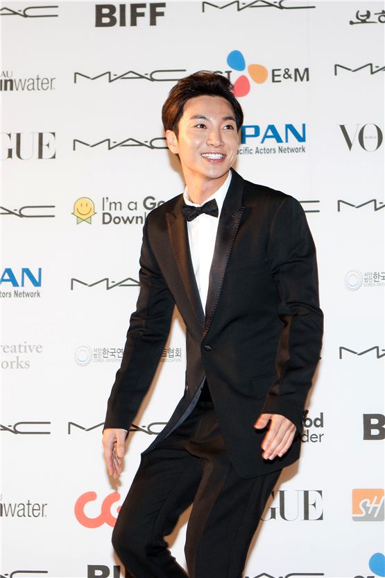 Super Junior's Lee Teuk smiles to roaring fans in front of the photowall during the APAN Star Road event of the 17th Busan International Film Festival in Busan, South Korea on October 5, 2012. [Lee Jin-hyuk/ 10Asia]