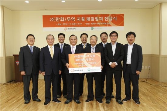 ㈜한화 무역부문 박재홍 사장(왼쪽 네번째)이 한국사회복지관협회 배윤규 회장(오른쪽 세번째)에게 패딩점퍼 전달식을 하고 있는 모습. 