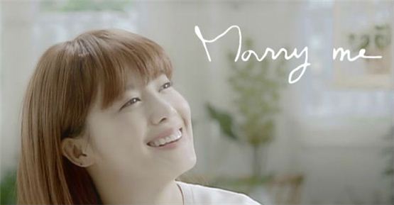 Ku Hye-sun smiles brightly in the music videoof her new song "Marry Me," released on October 15, 2012. [YG Entertainment]