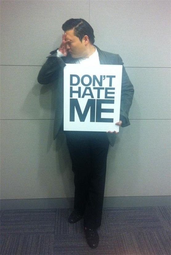 PSY holds up a sign read "DON'T HATE ME" with a worriful face in the picture uploaded on his official Twitter account on October 14, 2012. [PSY's official Twitter account]