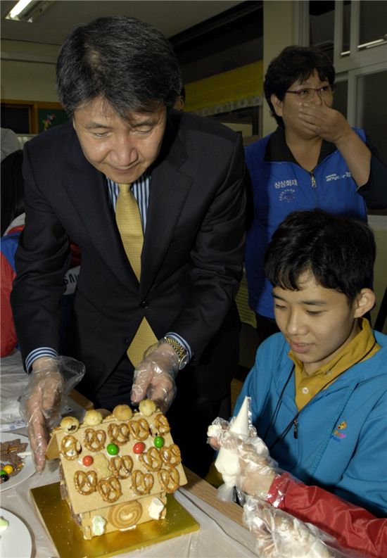 김창수 삼성화재 사장이 제주영지학교 수업 중 학생과 함께 과자집을 만들고 있다.