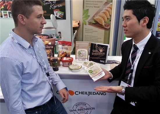 ▲CJ제일제당 담당직원이 2012 파리 국제식품박람회장에서 '햇반 저단백밥'을 소개하고 있다