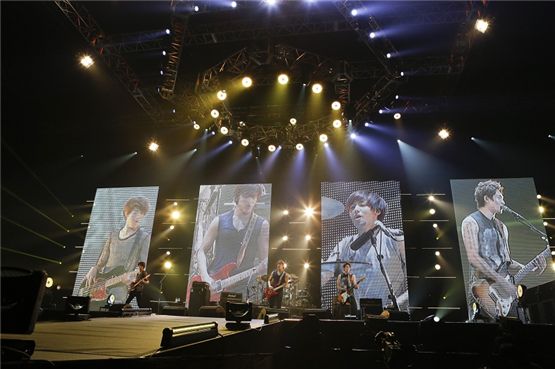CNBLUE members perform on the stage during the Saitama leg of "CNBLUE Arena Tour 2012~ COME ON~," held at Japan's Saitama Super Arena on October 20 and 21. [FNC Entertainment]
