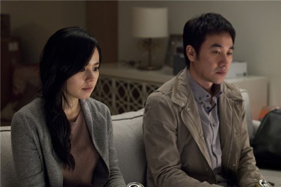 Actress Han Ga-in (left) and actor Uhm Tae-woong (right) sit on a couch together on the Jeju Shooting set of "Architecture 101," released on March 22, 2012. [Lotte Entertainment]