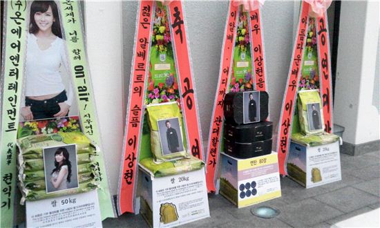 뮤지컬 '젊은 베르테르의 슬픔' 공연이 진행중인 서울 광진구 유니버설아트센터 앞에 팬들이 보낸 쌀화환과 연탄화환이 나란히 있다.