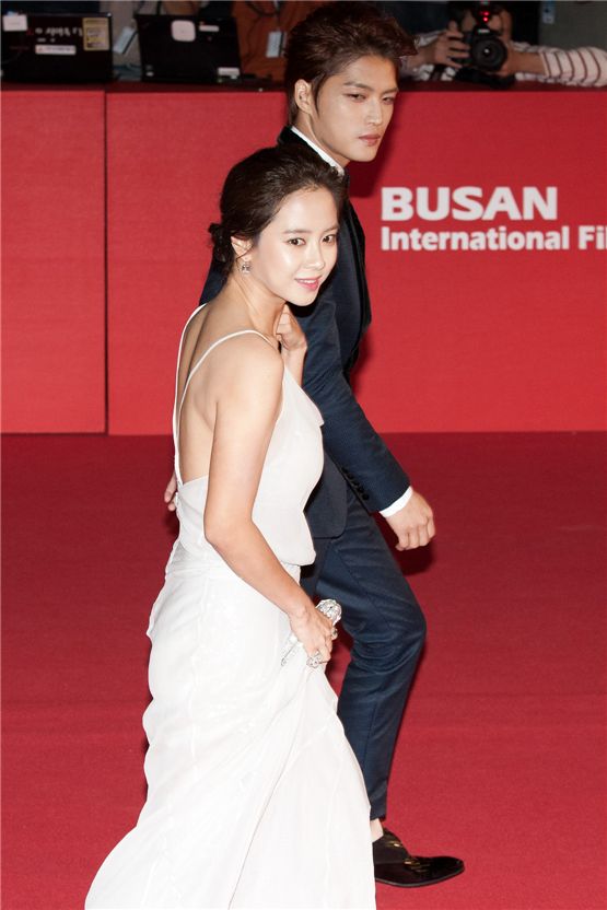 Korean actress Song Ji-hyo (left) and actor Kim Jae-joong of K-pop boy band JYJ walk down the red carpet at the 17th Busan International Film Festival's red carpet at the Busan Cinema Center in Busan, South Korea, on October 4, 2012. [Lee Jin-hyuk/10Asia]