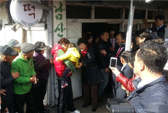 ▲박근혜 새누리당 대선 후보가 12일 전북 익산시 금마시장 내 방앗간 앞에서 한 아기의 손을 잡으며 웃고 있다. 