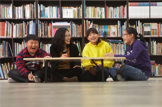 서울시 미아동 하늘씨앗지역아동센터 선생님과 어린이들이 보수가 완료된 공부방에서 환하게 웃고 있다.