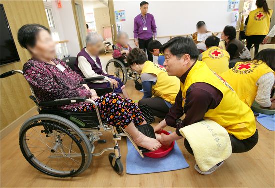 최창식 중구청장이 중구노인요양센터에서 한 어르신 발을 씼어주고 있다.