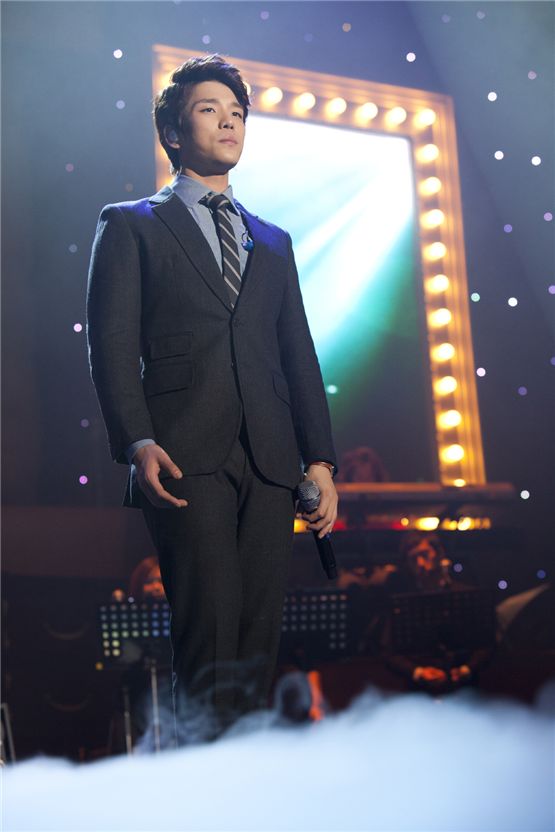 2AM member Changmin stands in a gray suit during their Seoul concert of the first Asian tour "The Way of Love," held at the Olympic Hall in Seoul, Korea on November 24 and 25, 2012. [CJ E&M]

