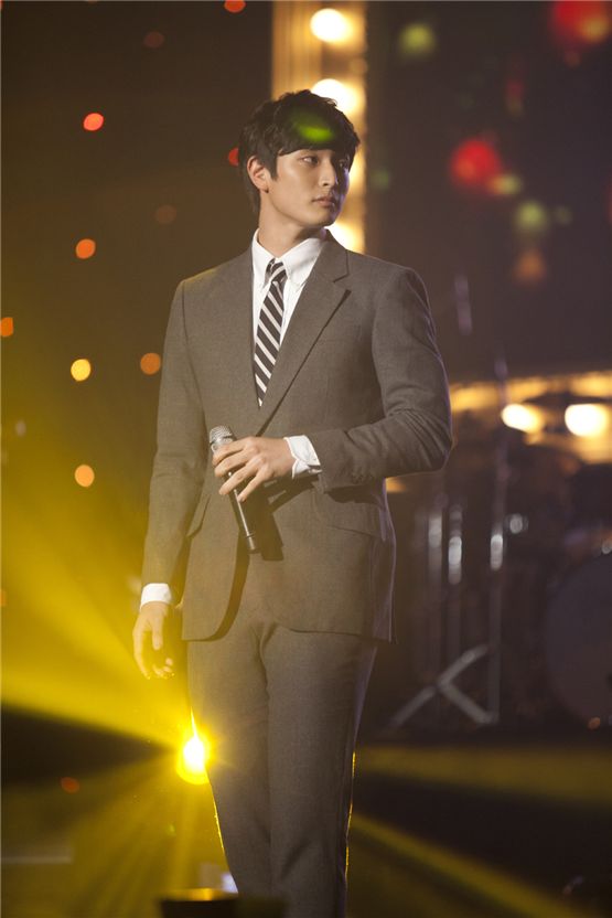 2AM member Jinwoon stands in a gray suit during their Seoul concert of the first Asian tour "The Way of Love," held at the Olympic Hall in Seoul, Korea on November 24 and 25, 2012. [CJ E&M]


