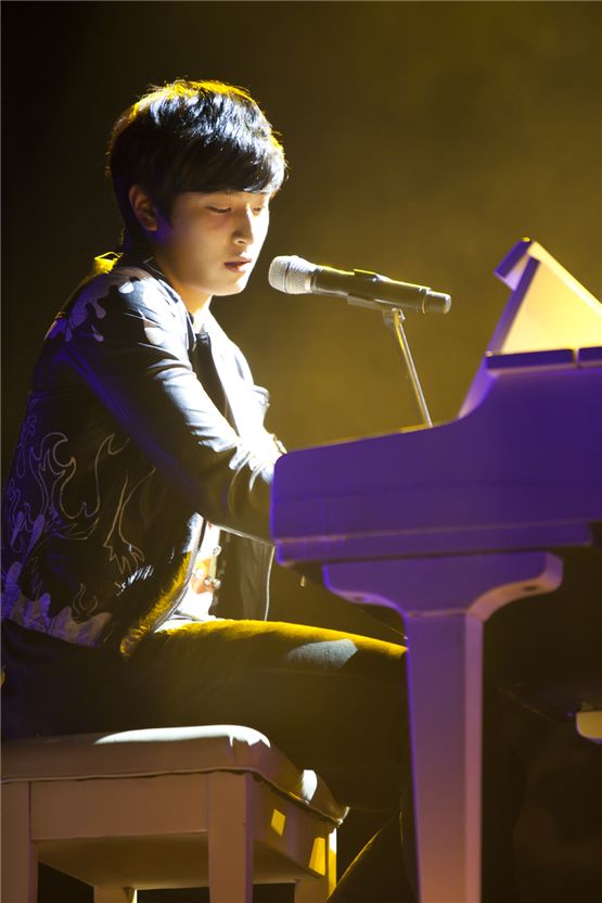 2AM member Jinwoon plays a piano during their Seoul concert of the first Asian tour "The Way of Love," held at the Olympic Hall in Seoul, Korea on November 24 and 25, 2012. [CJ E&M]