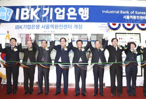 IBK기업은행은 26일 서울역 2층 맞이방에 환전센터 문을 열고 공항철도 이용 여행객을 대상으로 영업을 시작했다. 조준희 기업은행장(왼쪽 다섯번째)이 개점식에 참석해 주요 참석자들과 함께 손을 들고 환호하고 있다.
