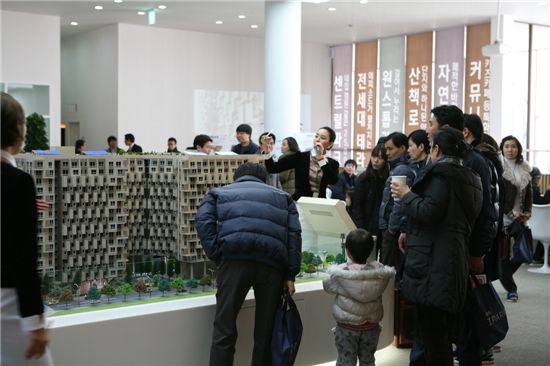 송파아이파크 견본주택을 방문객들이 건물 모형을 살펴보면서 분양관계자의 설명을 듣고 있다.