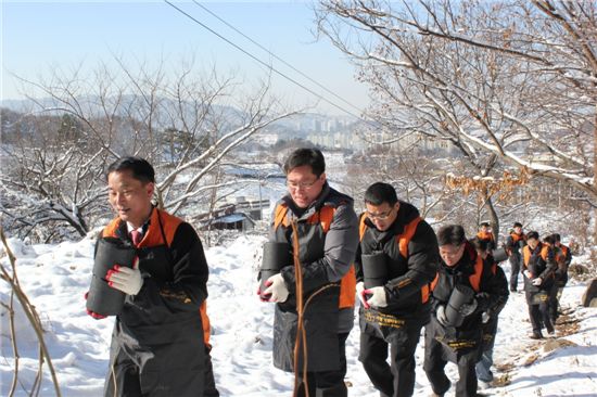 한화생명 봉사자 55명이 대전시 동구 삼정동 지역을 찾아 독거노인 50가구에 연탄을 배달하고 있다.