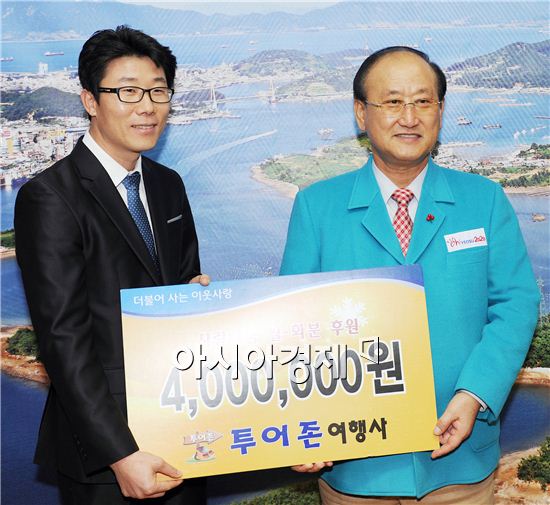 투어존 여행사 강호준 대표(왼쪽)가 김충석 여수시장에게 쌀과 화분을 기부하고 있다. 