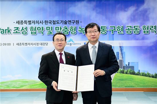 유한식(왼쪽) 세종시장과 홍순만 한국철도기술연구원장이 협약서를 펼쳐보이며 기념사진을 찍고 있다.