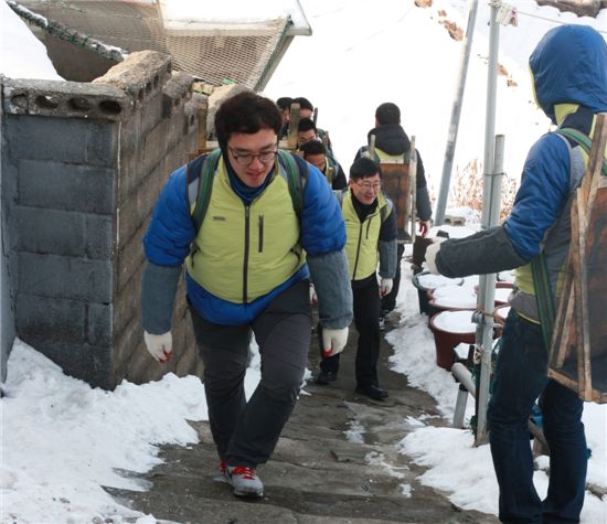 한양 임직원들이 인천 독거노인 가정에 연탄을 배달해주고 있다.