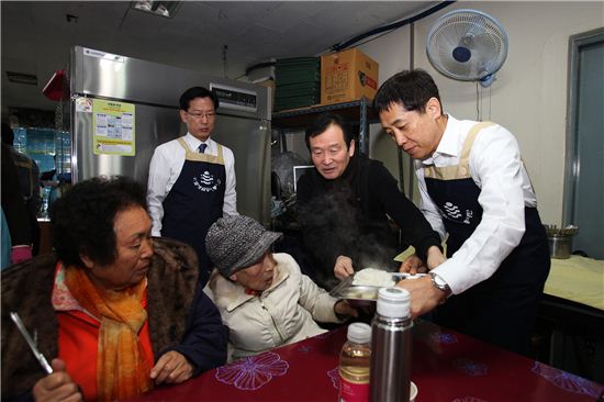 김주현 예금보험공사 사장(사진 오른쪽)이 권주웅 나눔의 둥지 회장(오른쪽에서 두번째)과 함께 무의탁 노인들에게 식사를 제공하고 있다.