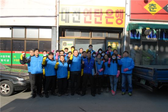 박경국(왼쪽 4번째) 국가기록원장, 권영수(왼쪽에서 3번째) 기록정책부장 등 국가기록원 간부와 직원들이 연탄을 전달한 뒤 화이팅을 외치며 기념사진을 찍고 있다.