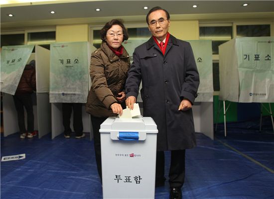 신연희 강남구청장과 남편이 투표 용지를 투표함에 넣고 있다.