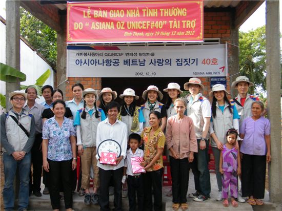 ▲19일(현지시간) 아시아나항공 캐빈승무원 봉사단체인 오즈유니세프 회원들이 베트남 번쩨성에 40번째 '사랑의 집'을 준공하고 현지 주민들과 기념 촬영을 하고 있다.