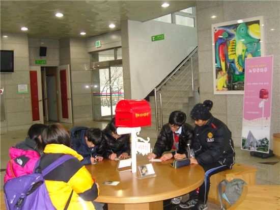 청주시립도서관 1층 문화사랑방 입구에서 1년 뒤에 받아볼 편지를 쓰고 있는 청소년들