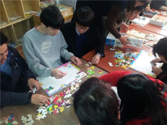 ▲대성산업 직원들이 어린이들과 퍼즐 맞추기를 하고 있다.(사진 회사제공)